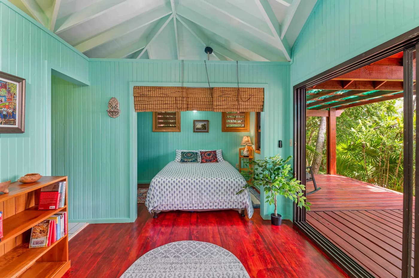 Saint Helene cabin with turquoise walls, a bed, kitchen and doors to the deck